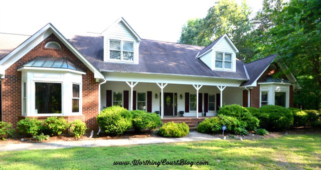 red brick two story ranch style house with large front porch