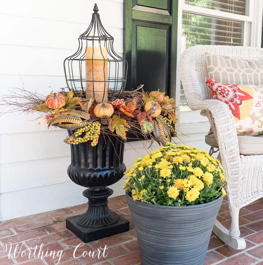 Black urn with fall picks and a lantern in the middle.