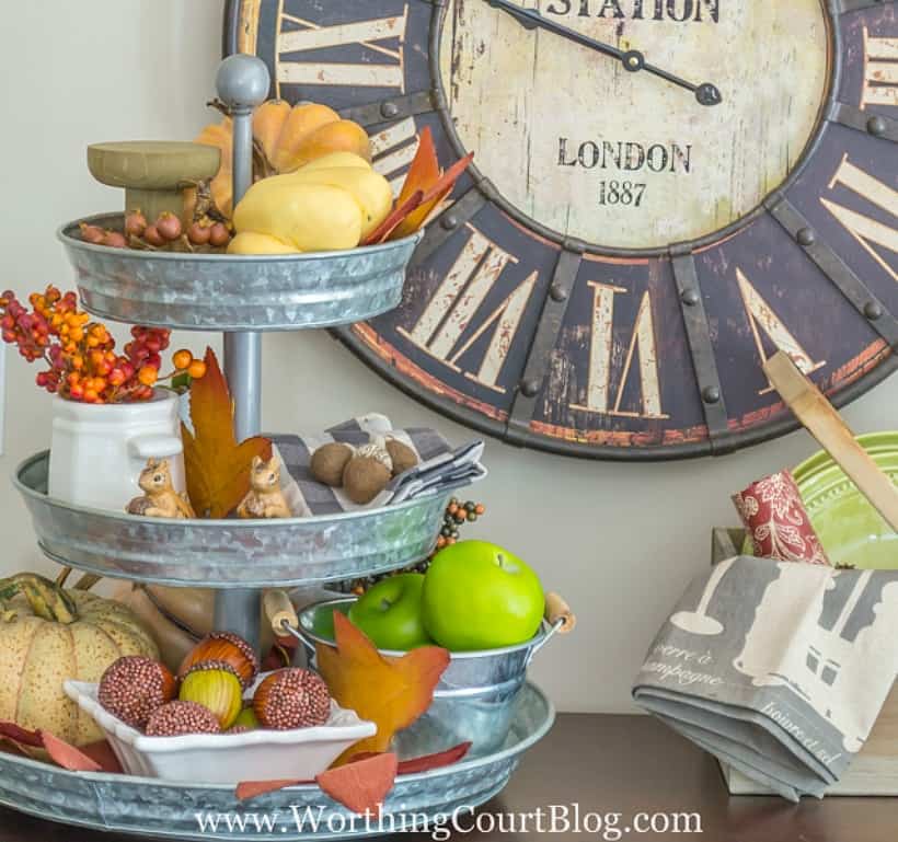 Metal tiered tray filled with a variety of fall decorations.