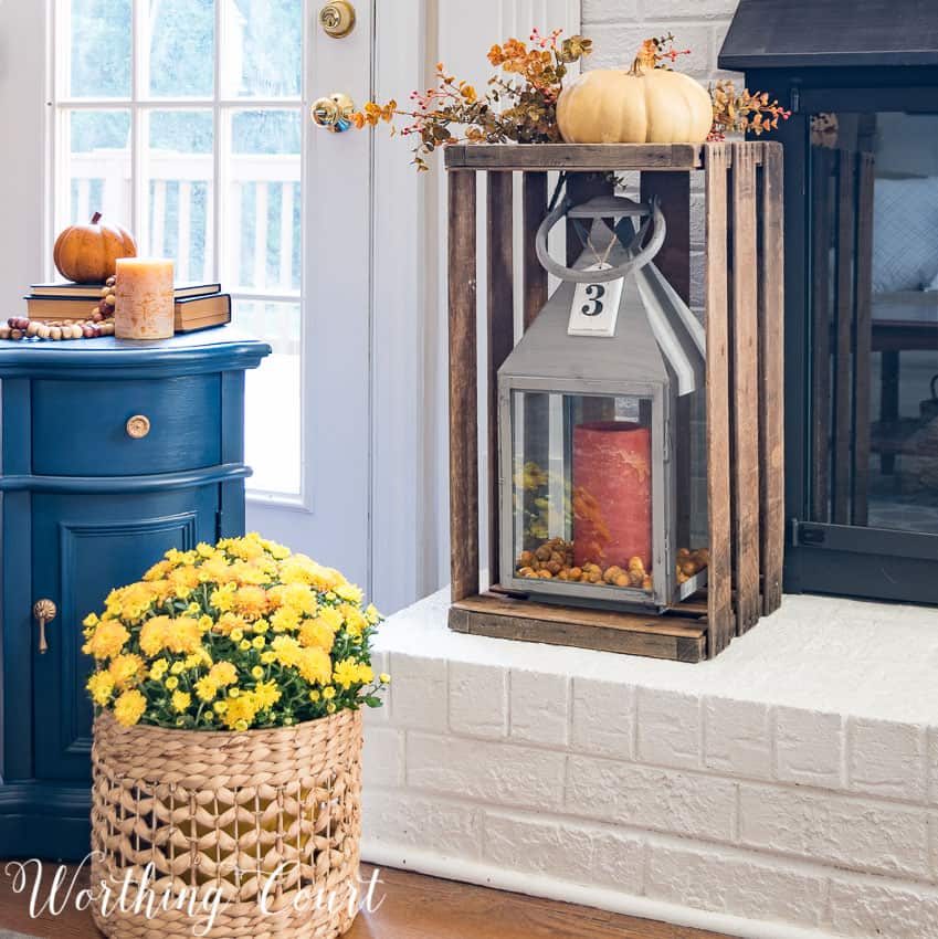 wooden crate on fireplace hearth with pumpkin on top