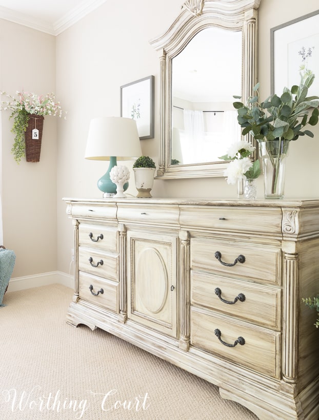 Traditional bedroom dresser painted with white paint and dry brushed with gray paint.