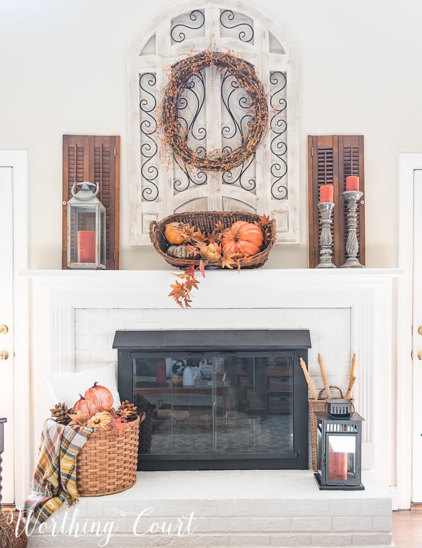 orange pumpkins displayed on fireplace mantel in wicker basket