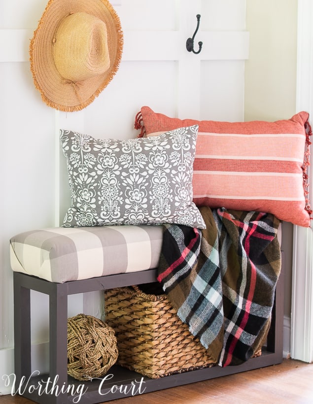 Bench with fall pillows and plaid fall throw blanket.