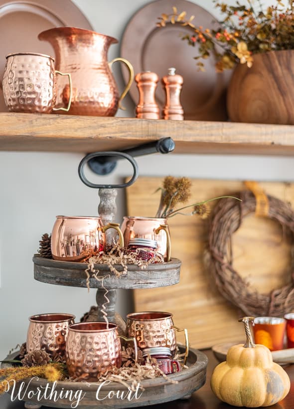 Open shelves decorated for fall with copper accessories.