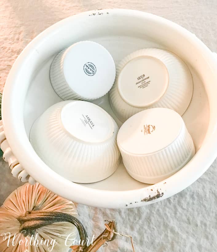 Placing the bowls upside down in the white urn.