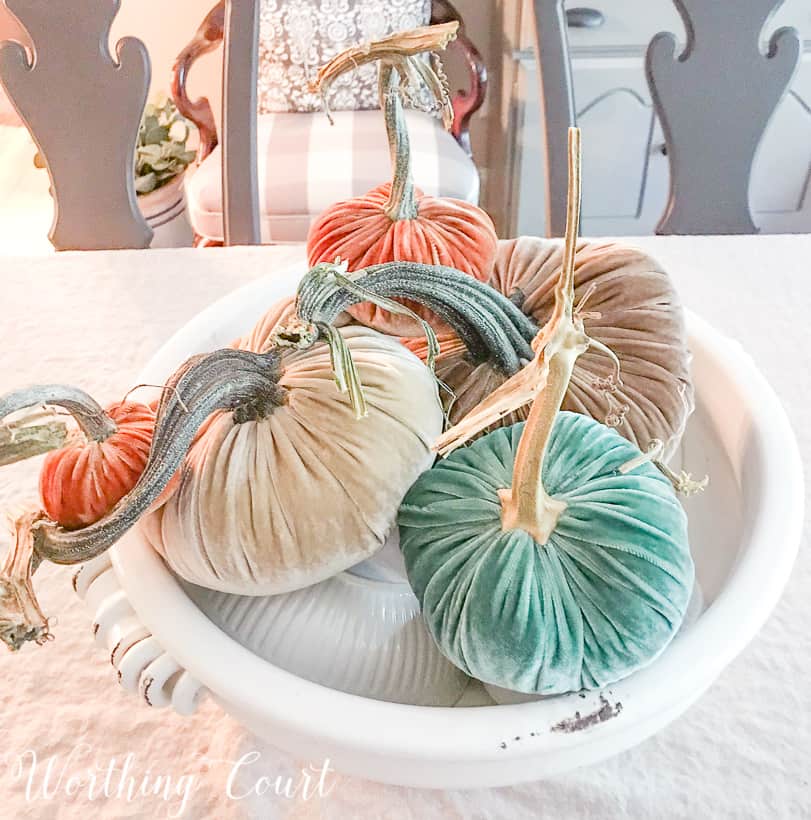 Arranging the pumpkins on top of the white bowls.