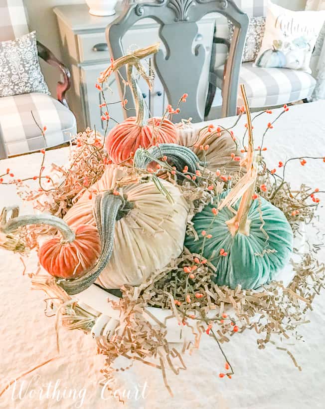 The white ceramic bowl is filled to the top and almost overflowing with pumpkins.