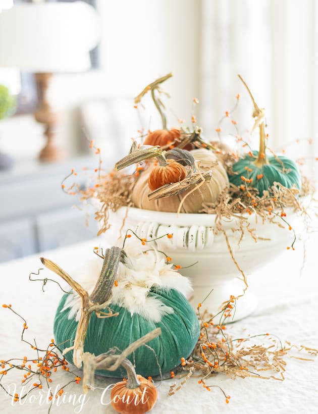 Fall centerpiece with velvet pumpkins green, neutral and orange.