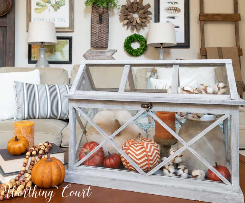 fall coffee table display with pumpkins in terrarium