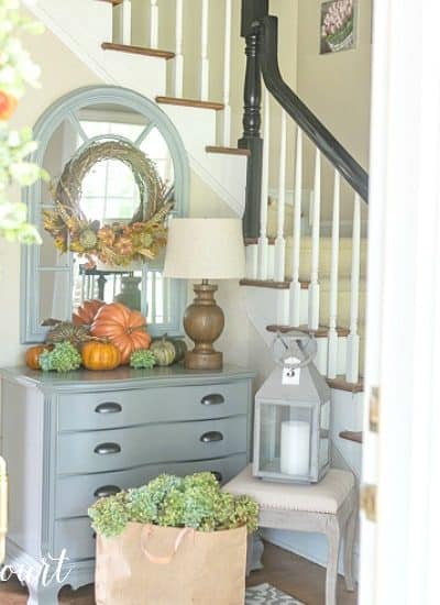 Entryway decorated for fall with pumpkins and a fall wreath