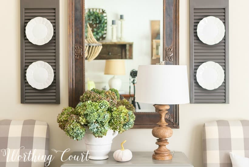 Dried hydrangea arrangement in white vase on gray chest