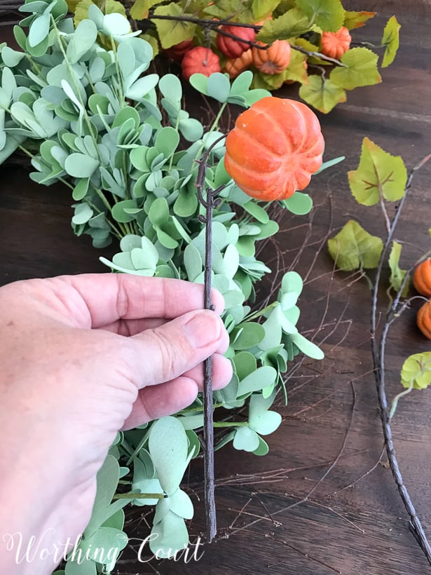 fall wreath with green leaves and pumpkins