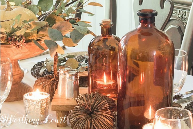 fall centerpiece with neutral colors and amber bottles