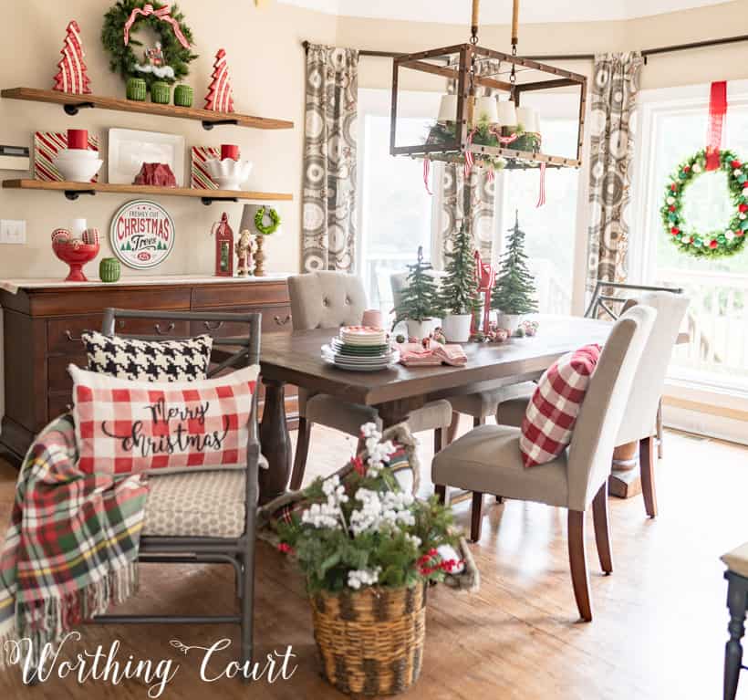 A chair is turned sideways in the room showing a Merry Christmas pillow in a checked pattern.