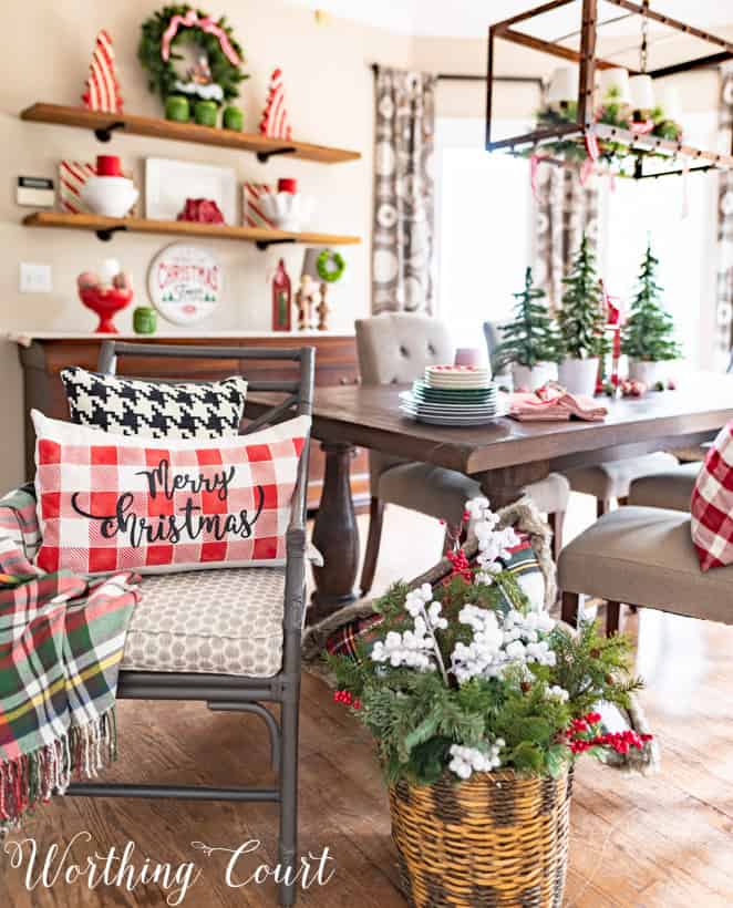 Christmas breakfast room decorations with holiday pillows on the chairs.
