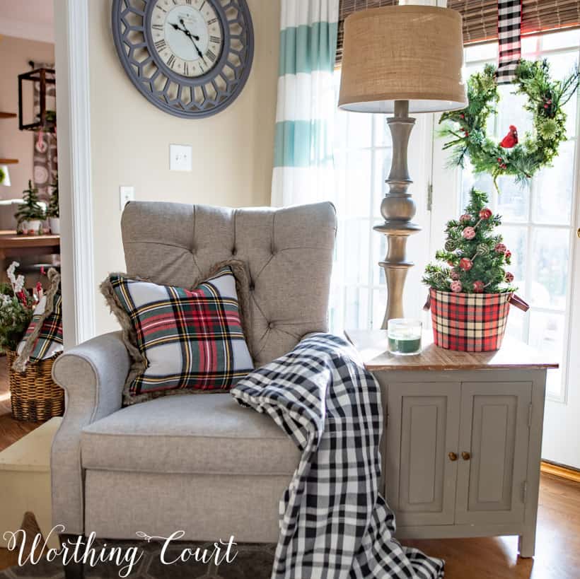 Neutral recliner with tufted back and a plaid pillow on the chair.