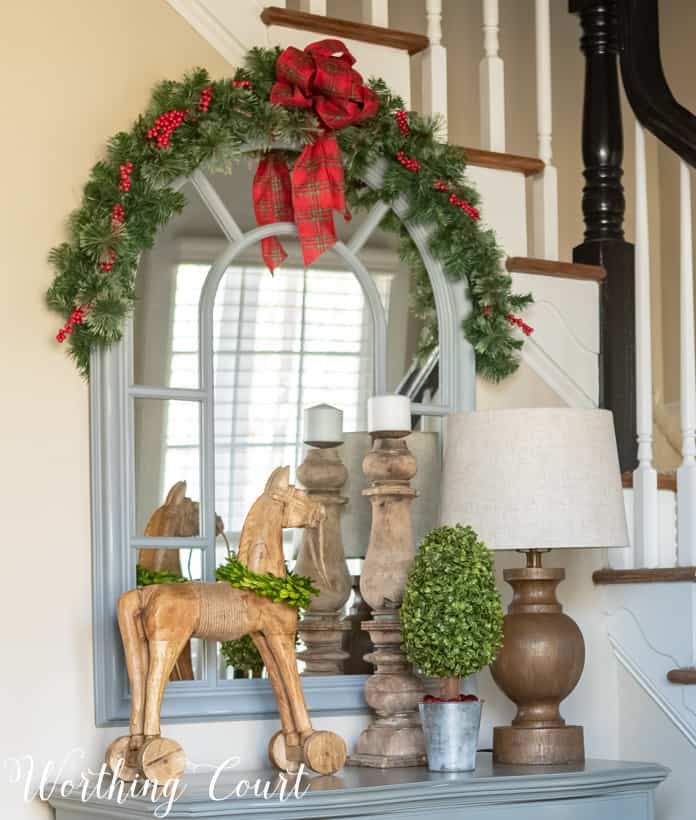 The mirror in the foyer decorated with garland and ribbon.