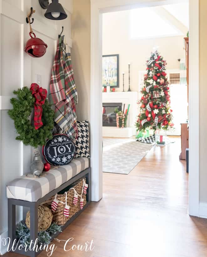 A small bench at the entrance with a wreath on the wall.