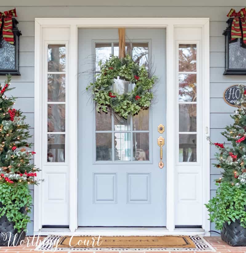 A light blue door with a green wreath and berries on it.