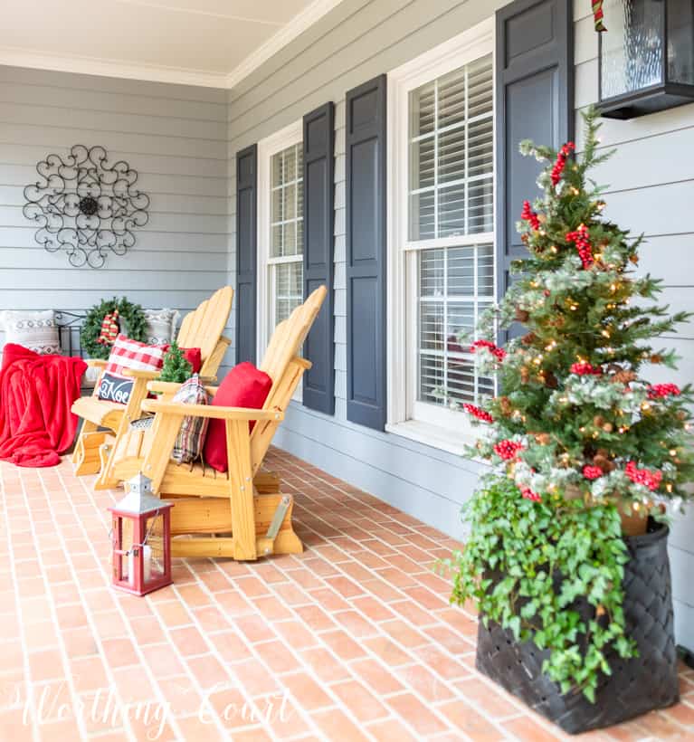 Red lanterns are beside the chairs on the porch.