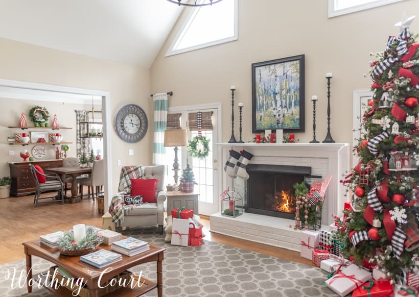 A cozy family room with a fireplace decorated for Christmas in red and green.