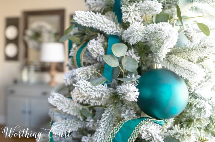 Flocked Christmas tree with teal decor.