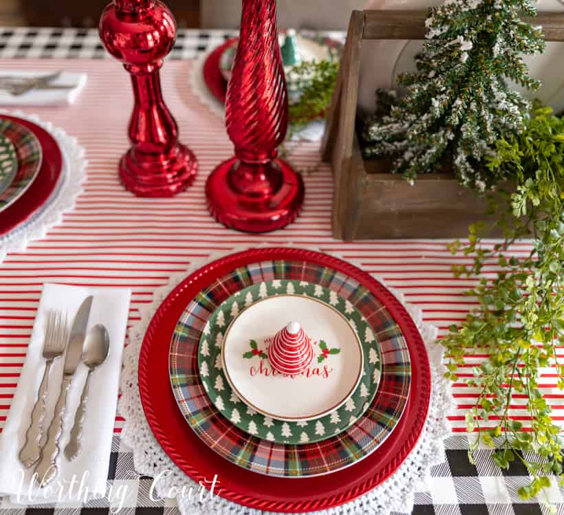 Plaid, red and Christmas plates are on the table.