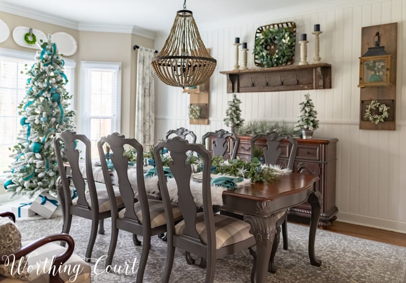 Teal Christmas dining room decorations with a large decorated tree at the foot of the dining room table.