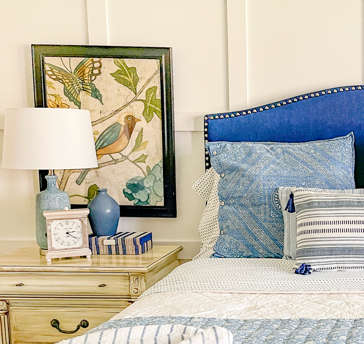 cottage style budget bedroom makeover with a navy blue upholstered headboard, board and batten feature wall, diy painted furniture and cottage style accessories