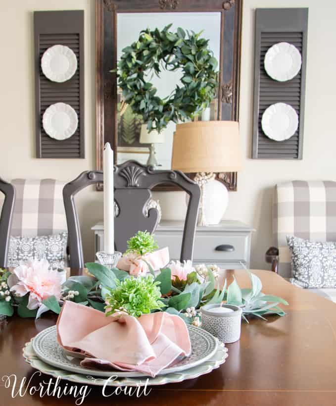 Dining room decorated for spring with flowers and pink napkins.