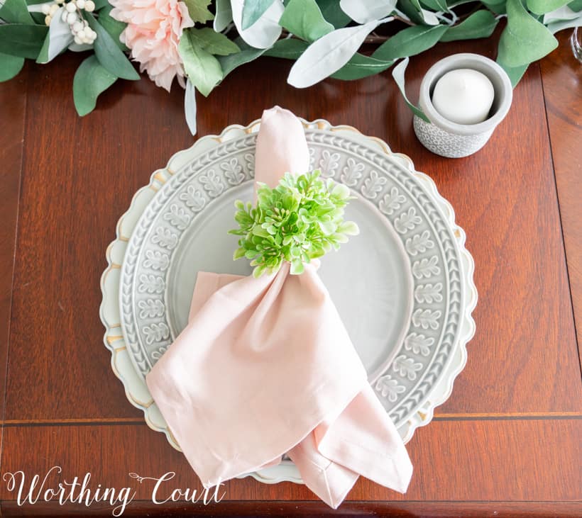 Table setting with gray dinner plate and pink napkin.