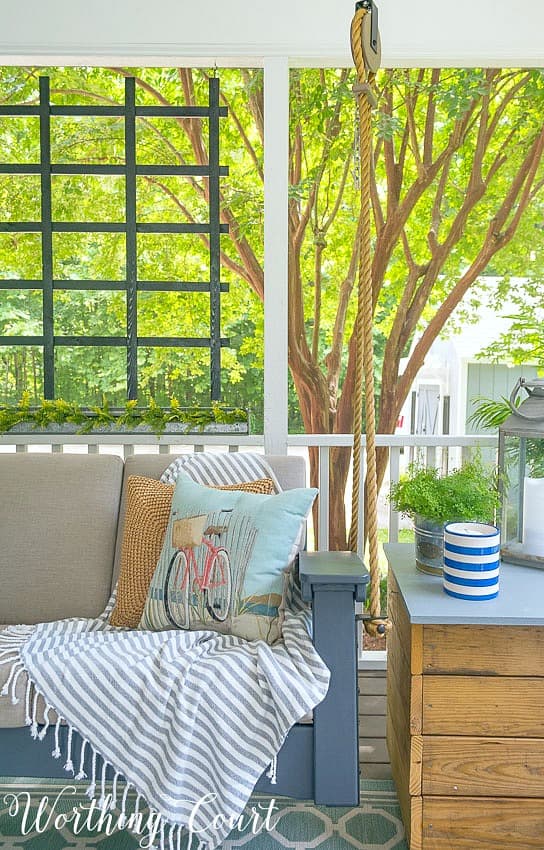 Beach bicycle throw pillow on a porch swing.