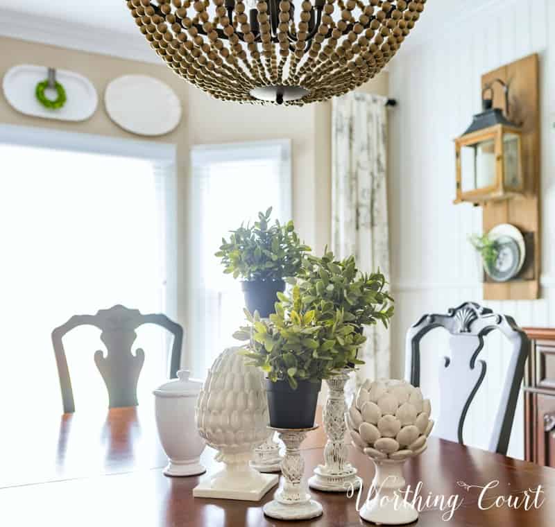 Spring centerpiece with white accessories and greenery.