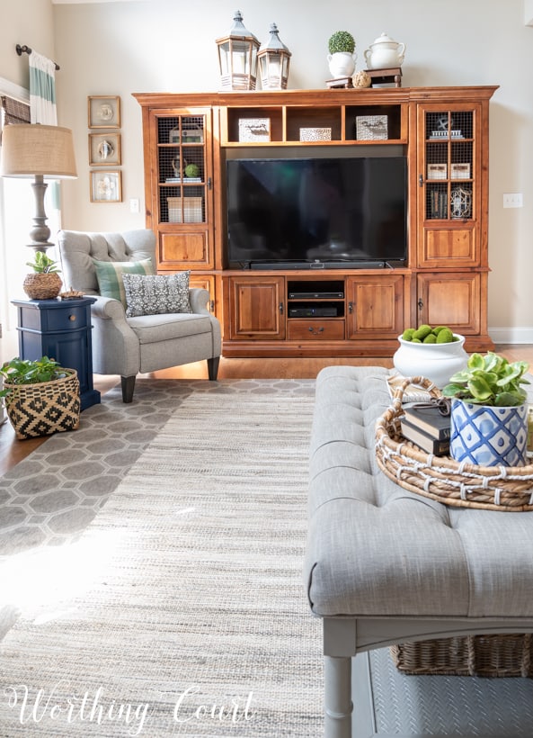 There are grey rugs on the floor layered for texture.