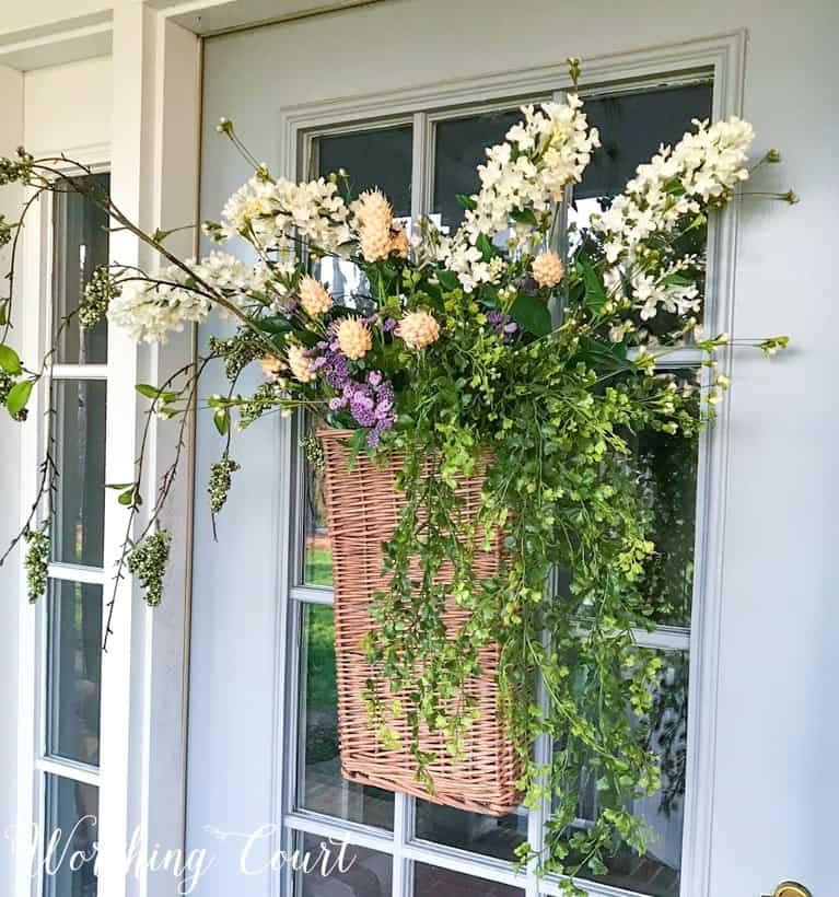 long hanging basket on front door filled with faux greenery stems