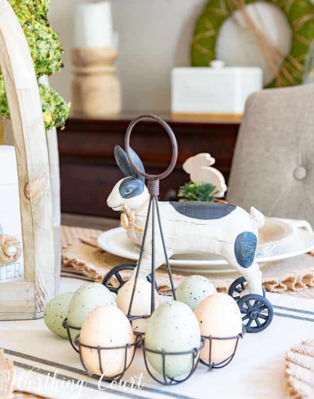 black and white Easter decorations with coloured eggs in a white egg holder.