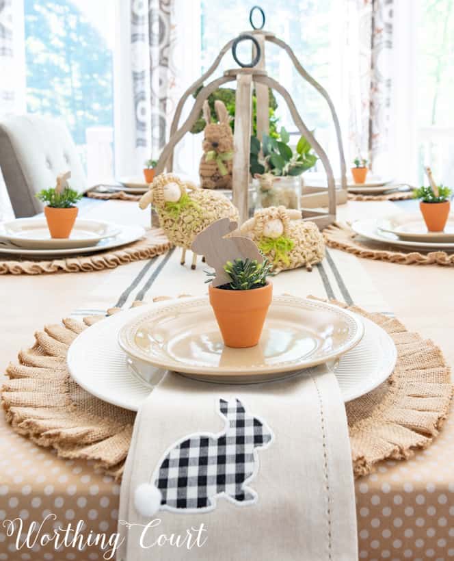 Easter place setting with a round burlap placemat and a bunny napkin.