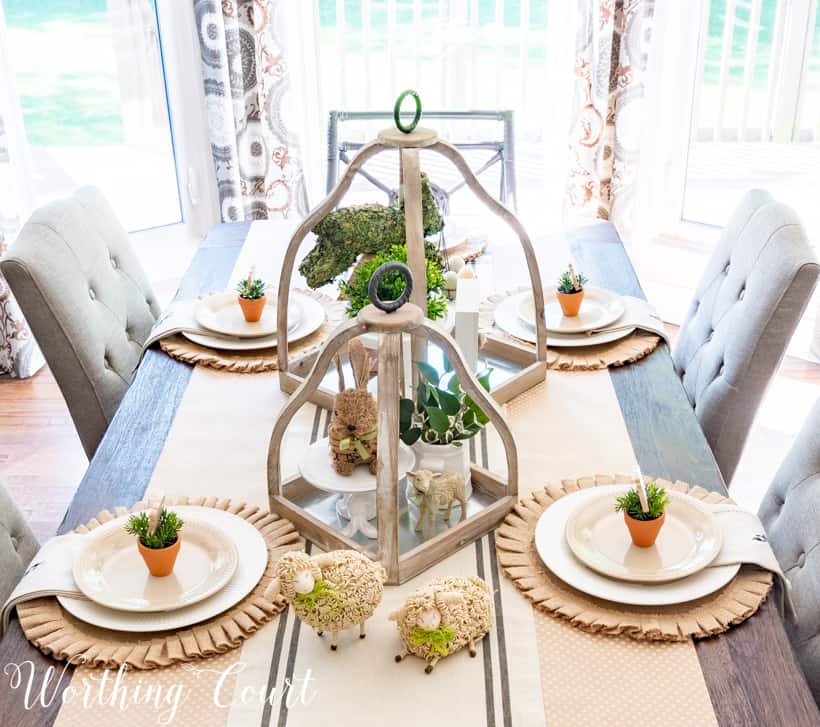 The tablescape with small sheep on the neutral table runner.