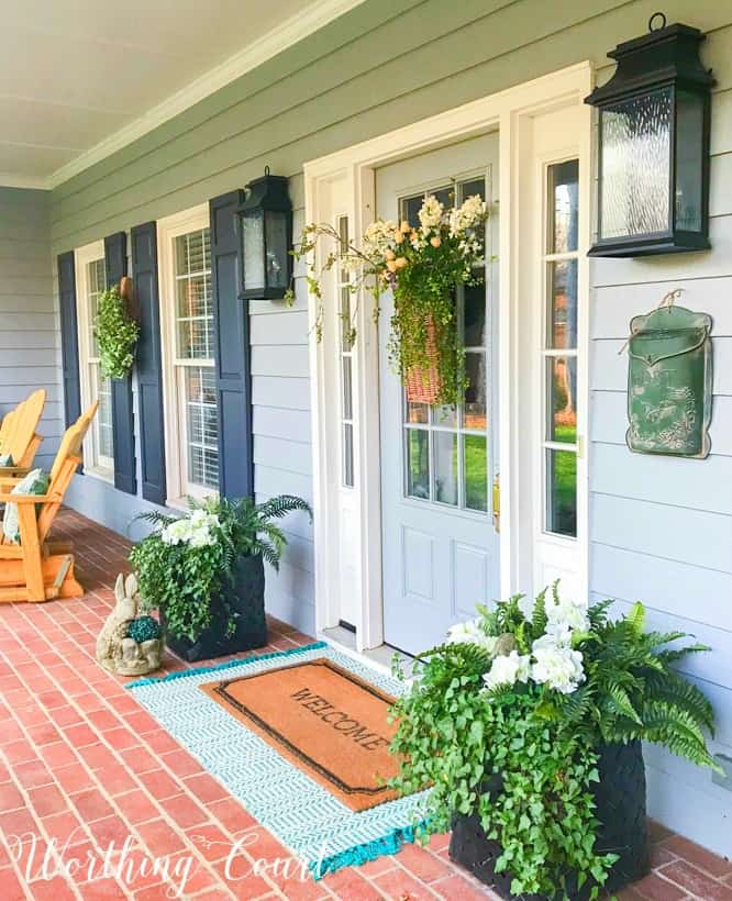 front porch with gray siding and gray front door with sidelights