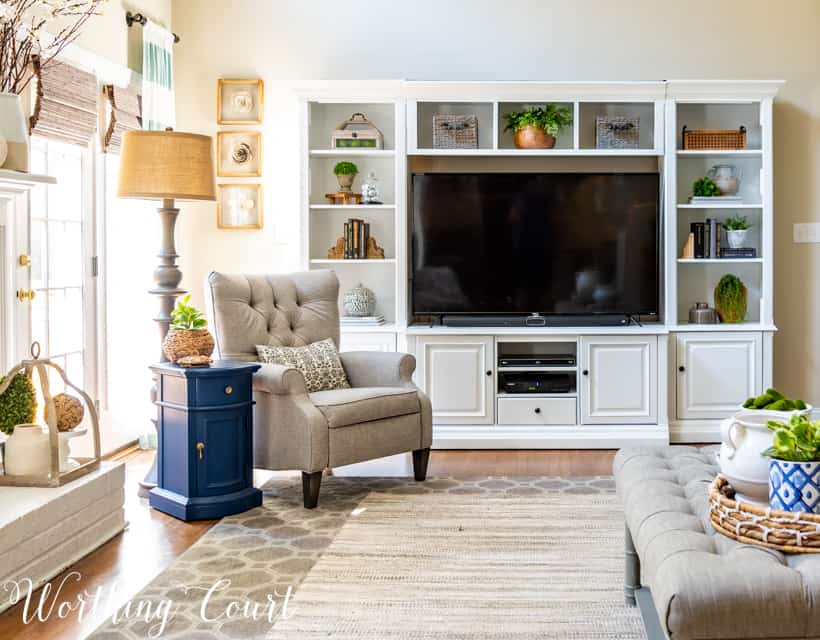 White entertainment center and a blue side table in the living room.