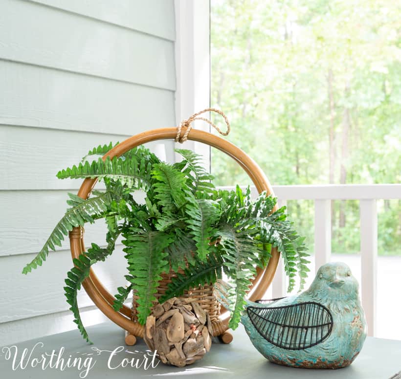 outdoor vignette on a sidetable with bird and fern