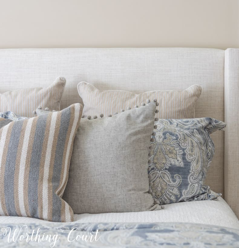 solid, stripe and paisley pillows displayed on a bed