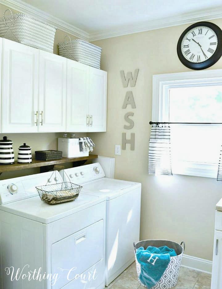 laundry room with white cabinets and beige walls