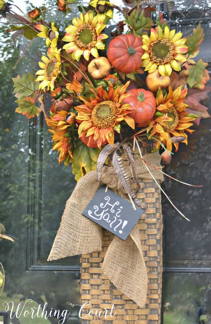 hanging basket on a front door filled with fall floral stems