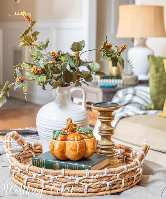 round wicker tray holding fall decorations