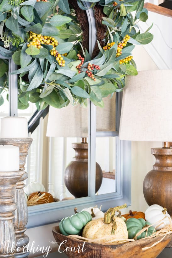 entry table decor for fall with a doughbowl filled with pumpkins