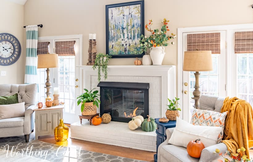 neutral living room and white painted brick fireplace with fall decor