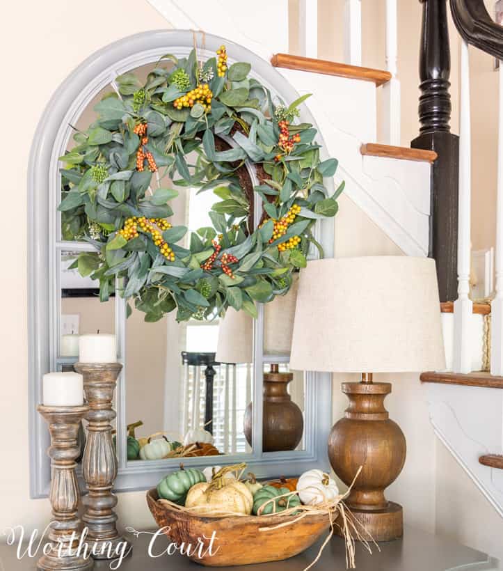 fall entry table decor with pumpkins, candlesticks and a lamp