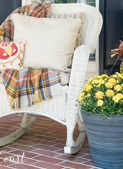 white wicker rocking chair with fall pillows