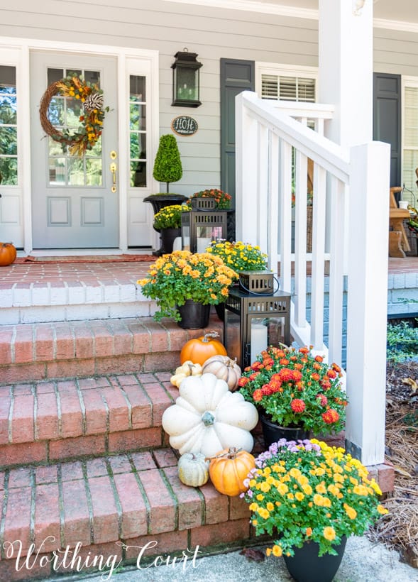 front porch decor ideas showing mums trailing up porch steps